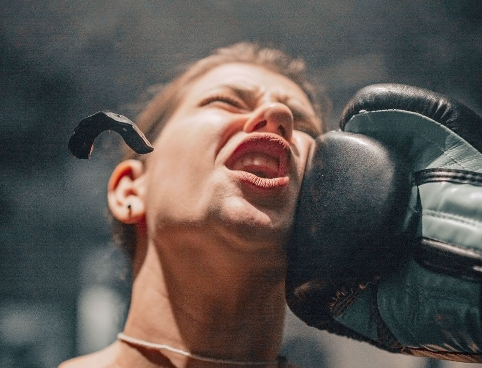 A boxer has their ill-fitted athletic mouthguard knocked out during a match