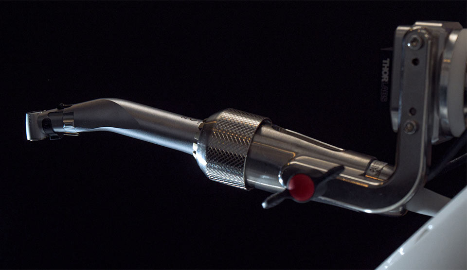 The arm that holds the dental tools is shown. For the Yomi robotic dentistry services landing page.