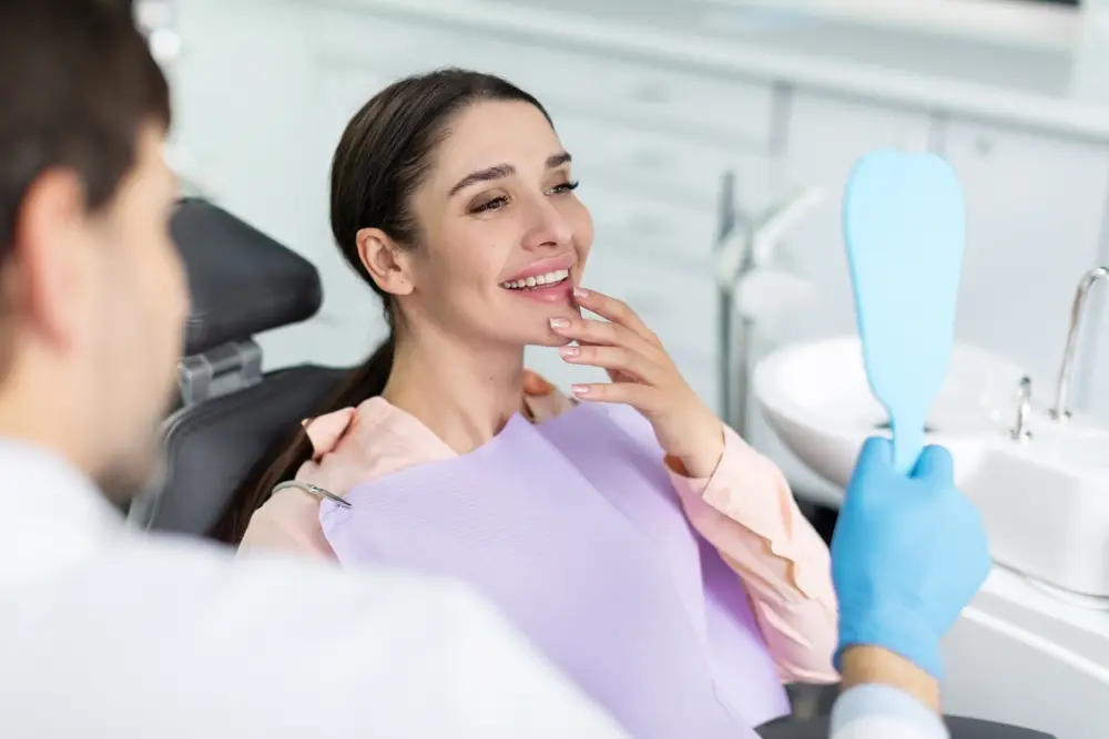 A smiling woman looking at her dental implants